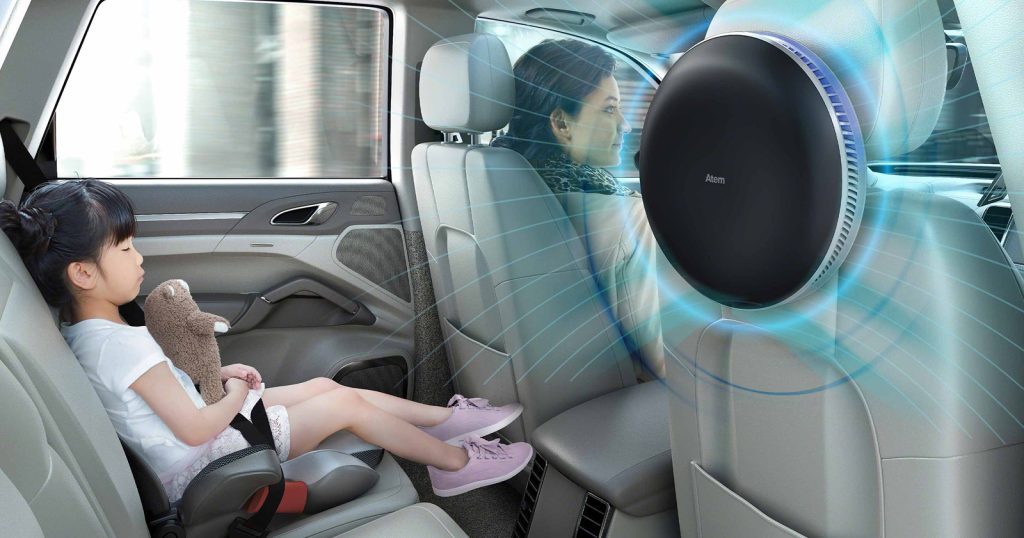 Air purifier behind front seat of car with a family inside